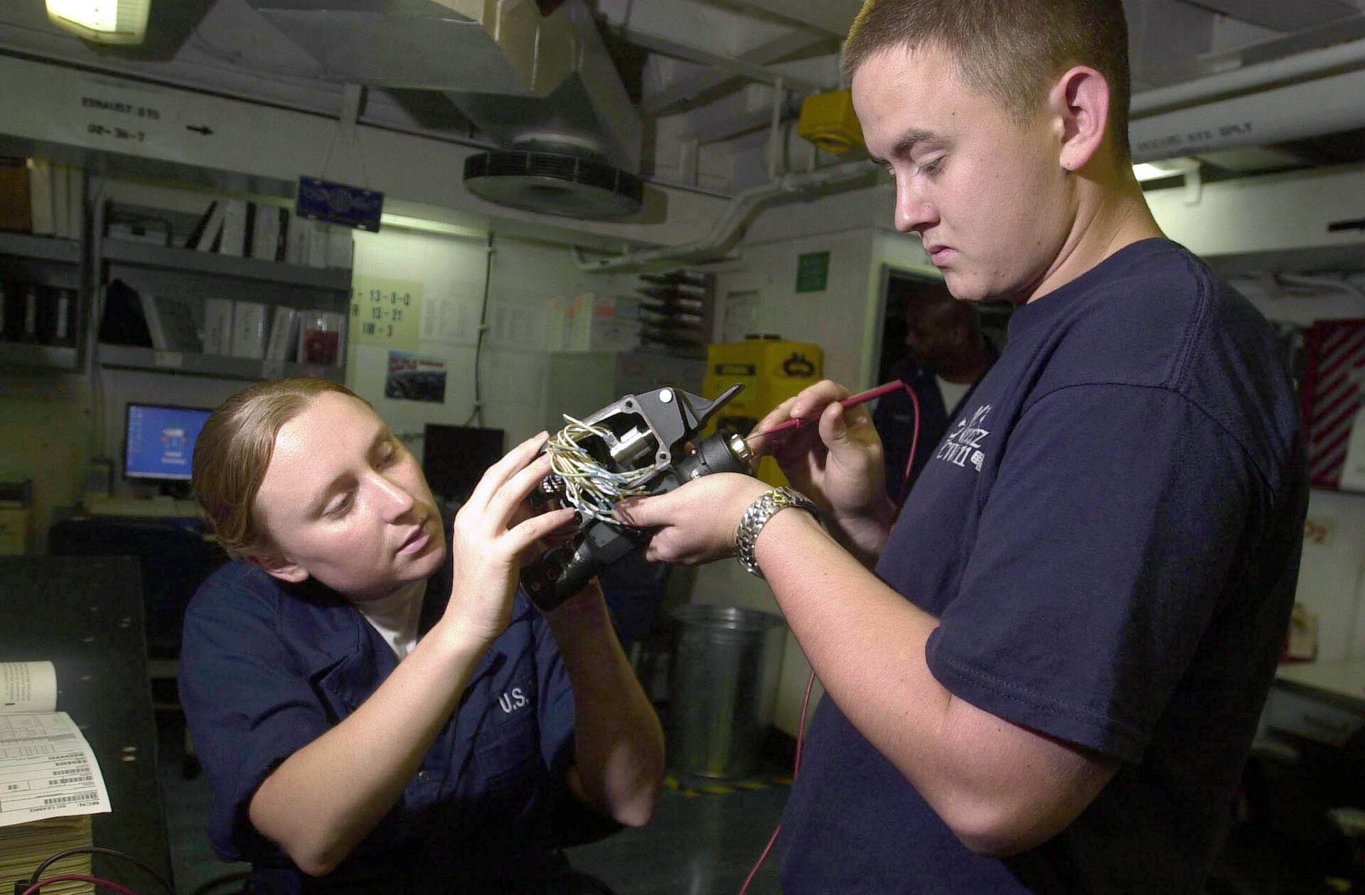 Technicians maintaining an aircraft equipment bay