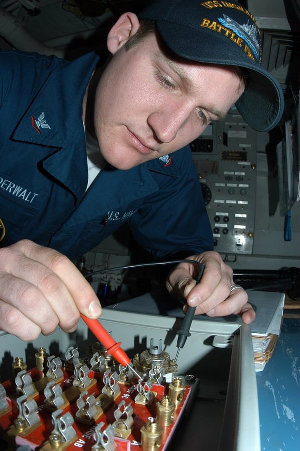 An electrician locating a fault with a multimeter; public maintenance reference.