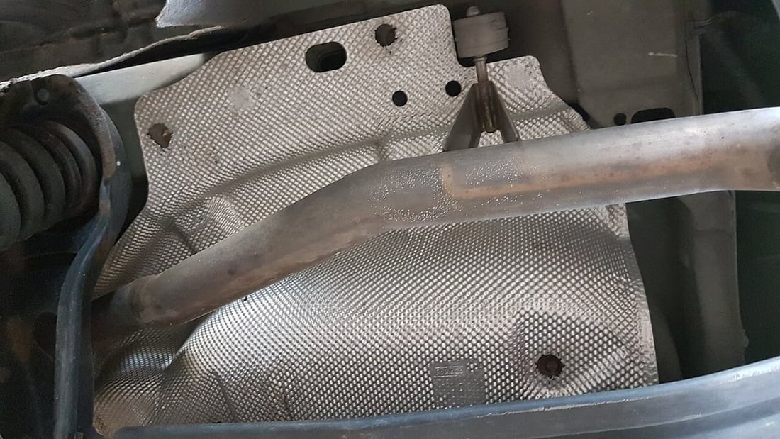 An exhaust heat shield illustrates why local radiant heat must be reviewed separately from ambient temperature.