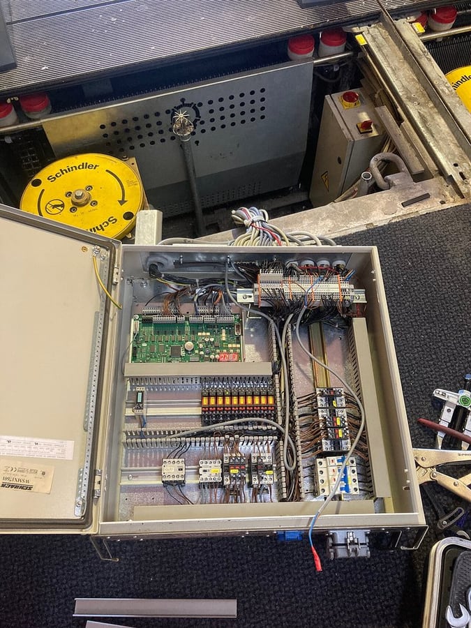 An escalator control cabinet shows power and control circuits sharing equipment space, not a specific hybrid connector.