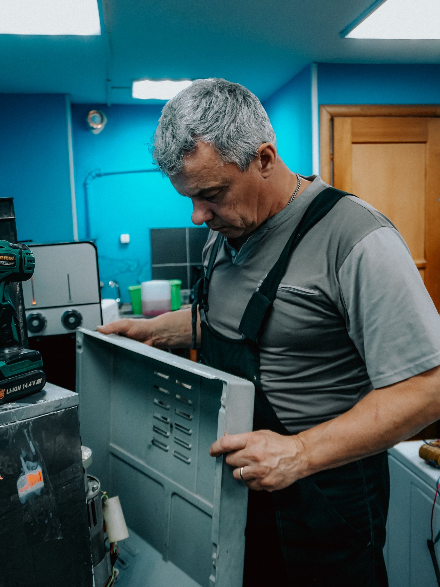 Technician servicing the internal electrical area of an appliance