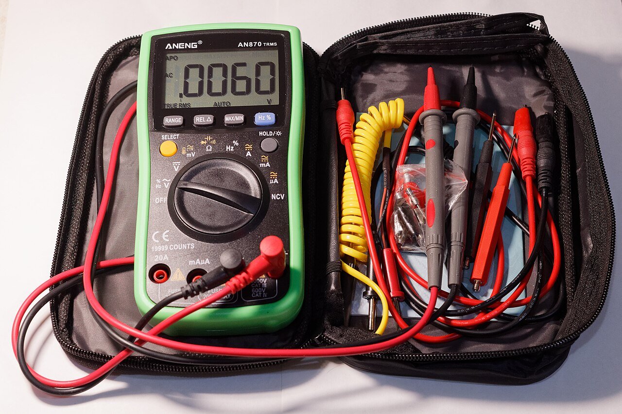 Meter and probes illustrate test equipment, not a recorded battery-cable test result.
