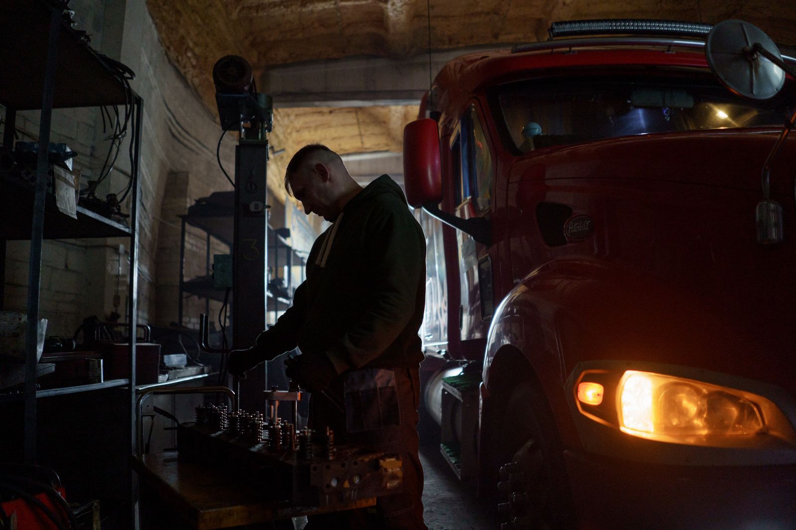 Mechanic servicing a heavy truck in a workshop