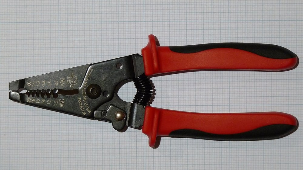Gauged wire-stripping scissors illustrate controlled end preparation before assembly.