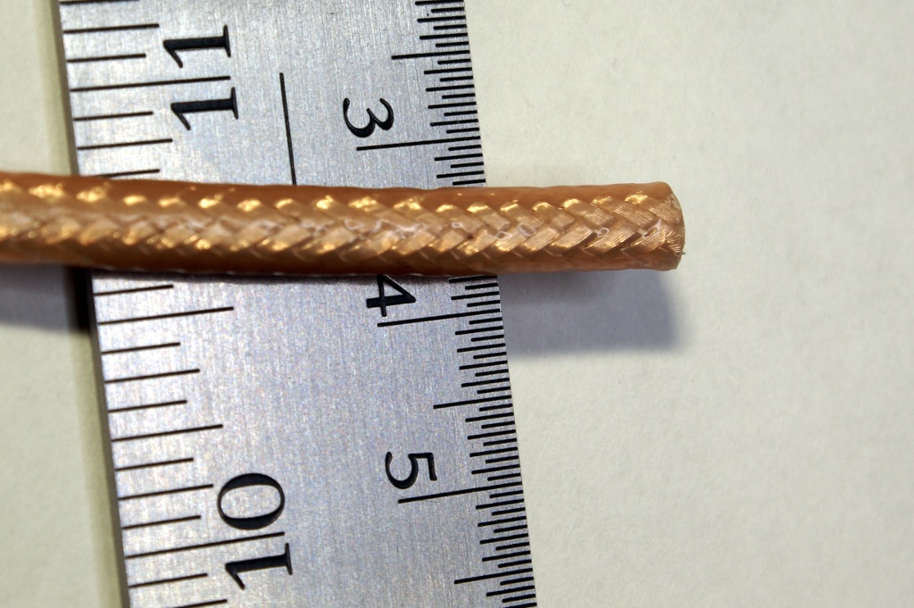 RG-142 coaxial cable with visible metal braid beside a ruler