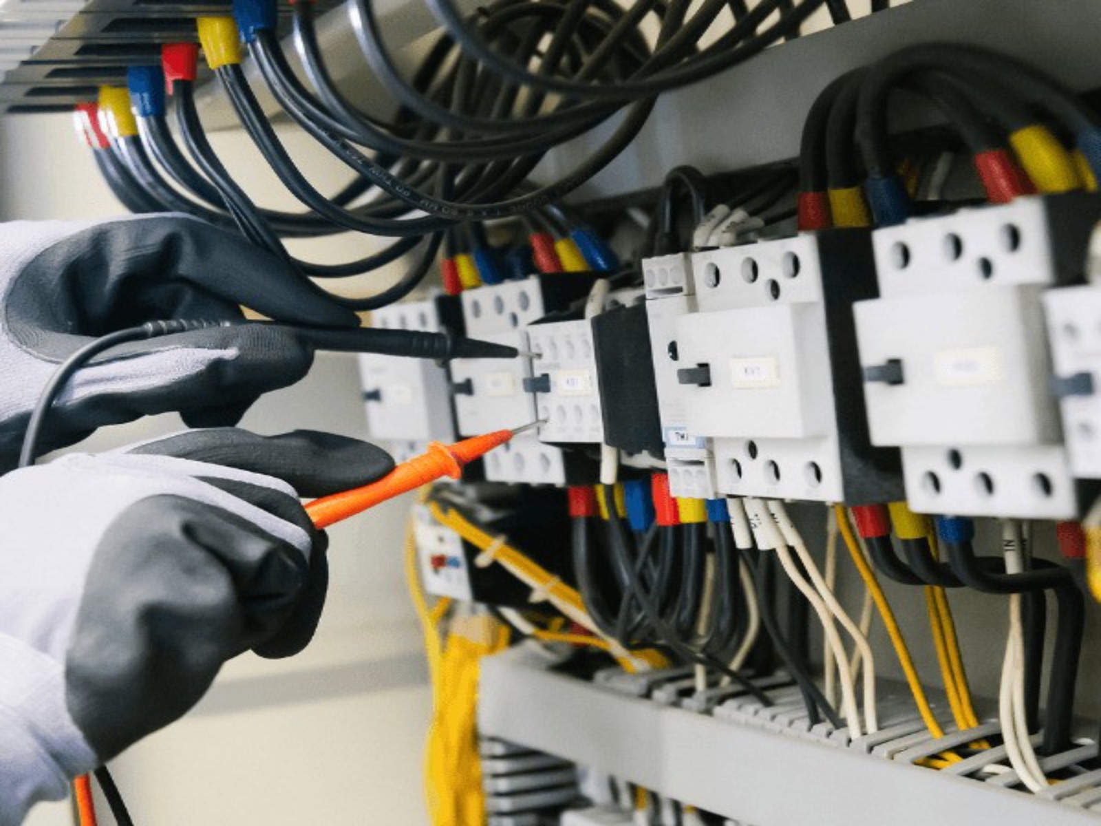 Technician checking electrical panel circuits with a handheld meter