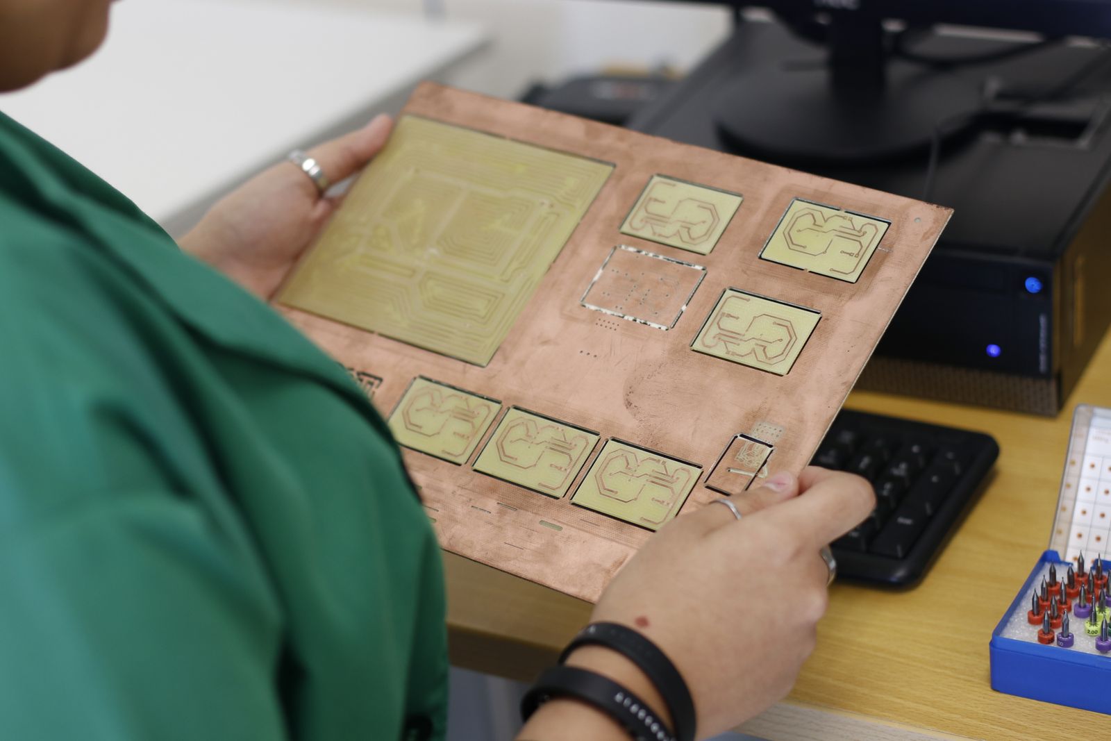 Hands inspecting an opened electronic device and circuit board