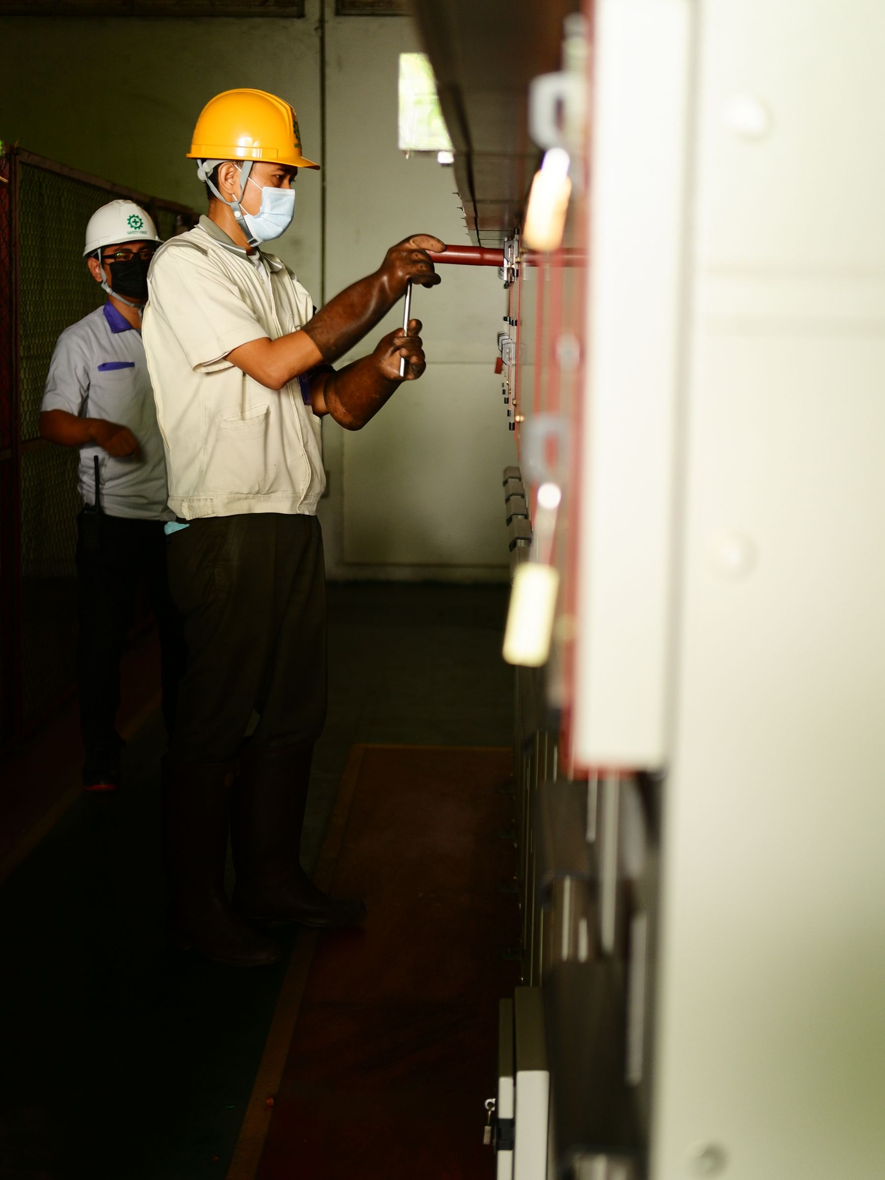 Electricians working at an industrial electrical panel
