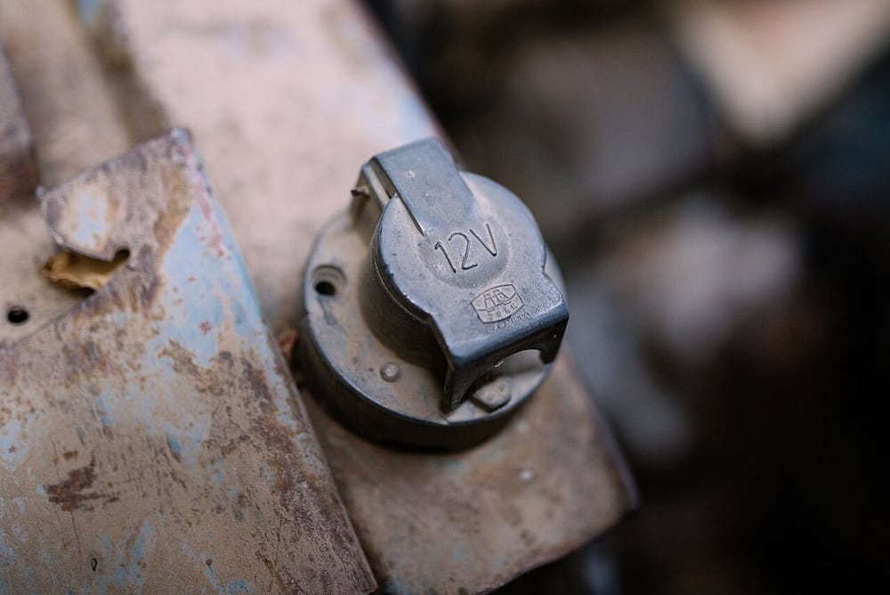 A weathered tractor outlet illustrates the installation environment around a protected connection.