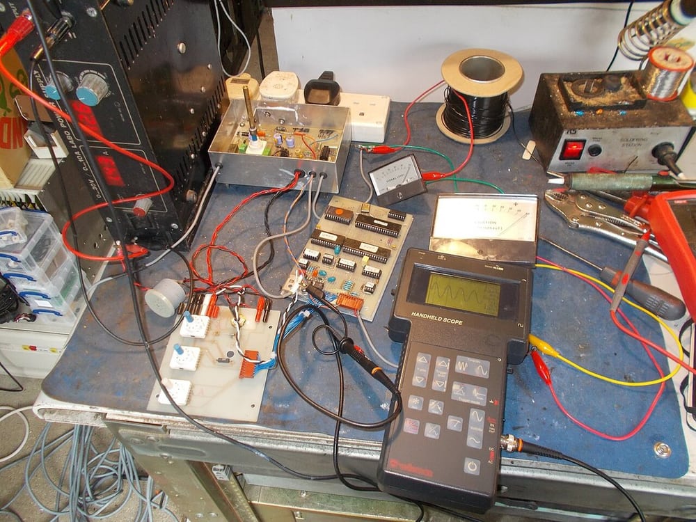 An electronics test bench illustrates checking a defined assembly before release.