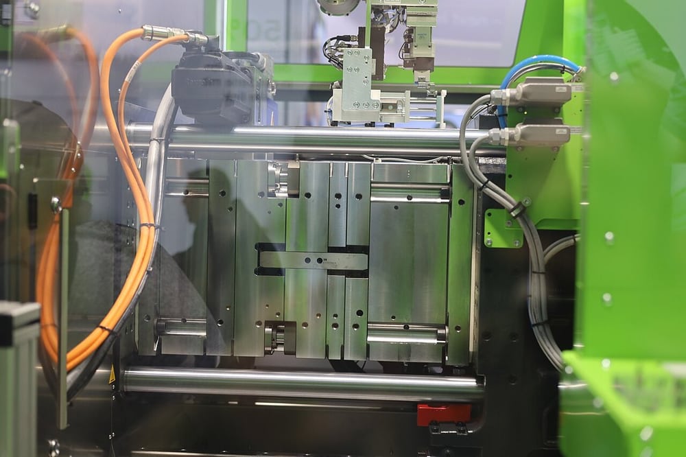 An injection-moulding machine illustrates control of plastic-part processing.