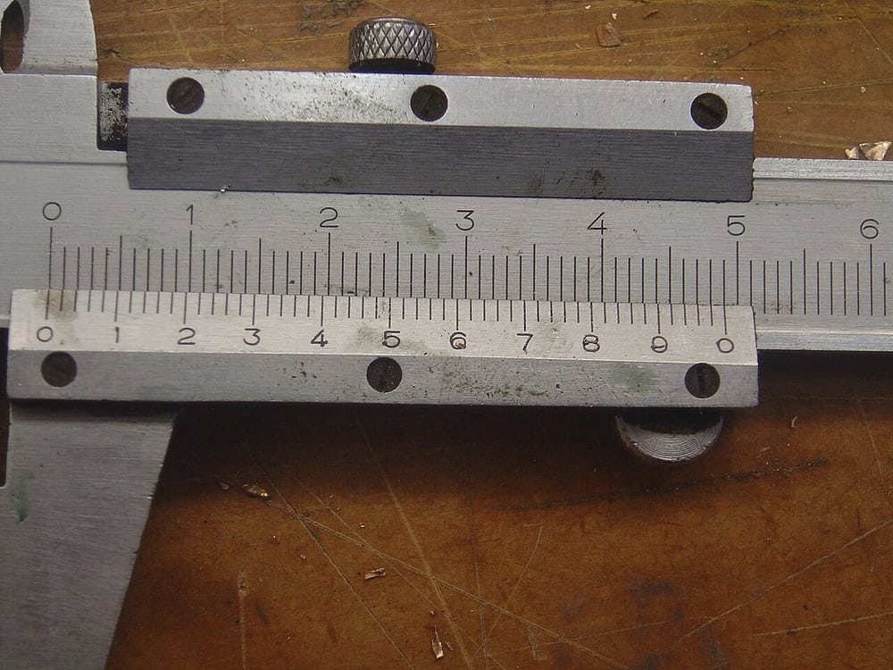 Caliper scale close-up: define the measurement datum and method on the drawing.