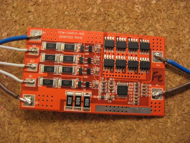 A small battery-management board illustrates low-voltage monitoring, not traction-power cabling.