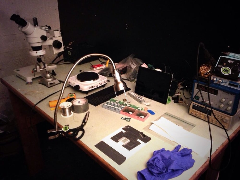 Electronics workbench with microscope and soldering equipment; prototype-work reference.