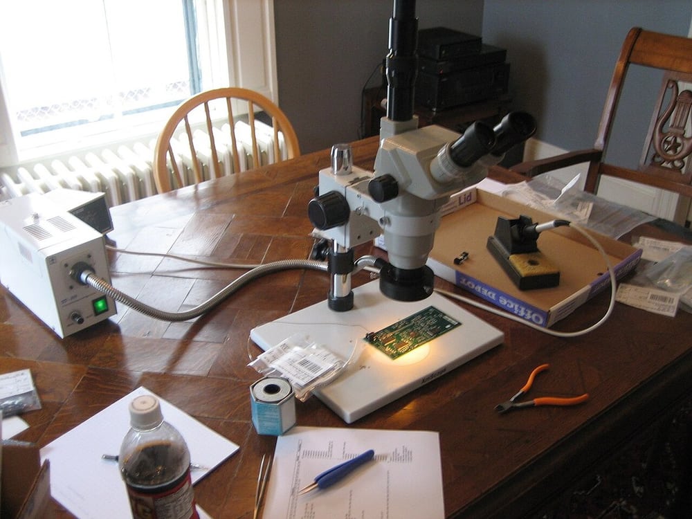 Microscope-assisted electronics work illustrates close visual access, not a completed inspection record.