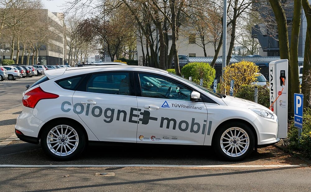 An electric vehicle at a charging point illustrates system context, not cable qualification.