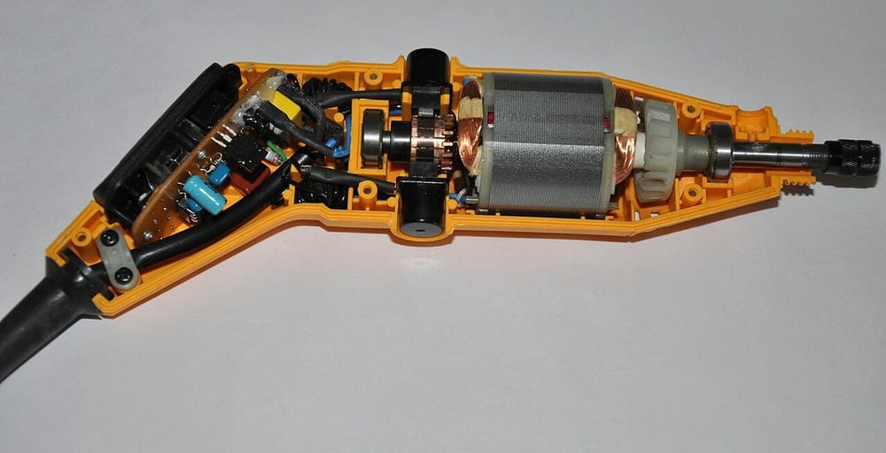 An opened compact power tool illustrates internal routing around a motor and controller.