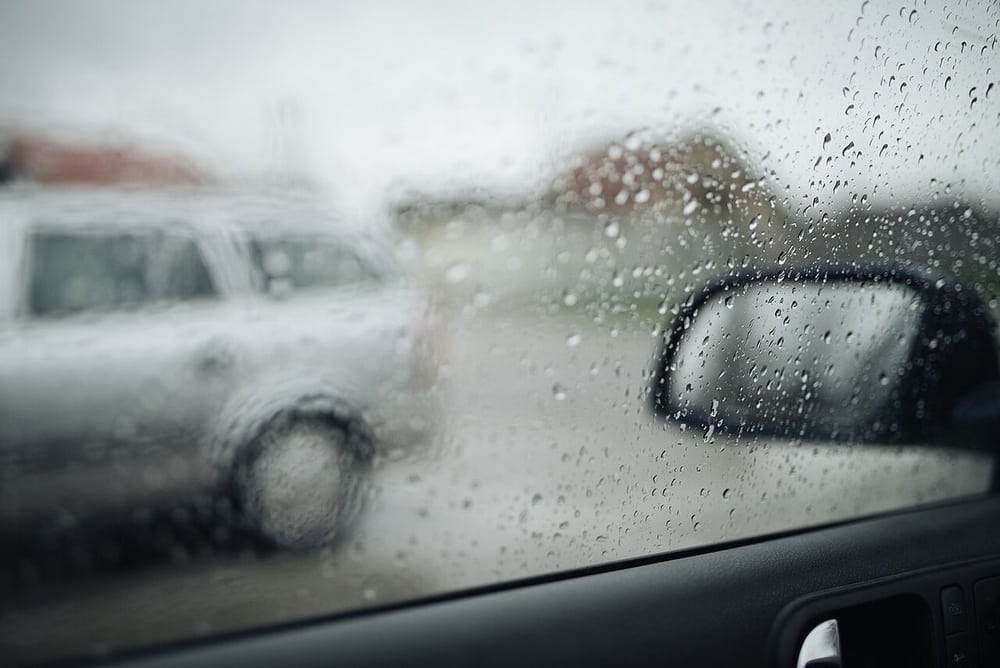 Rain at a vehicle window illustrates exposure to water, not a harness ingress test.