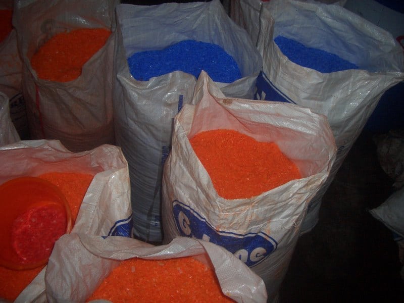 Bagged resin granules illustrate raw-material handling; the polymer grade is not identified as JAE housing material.