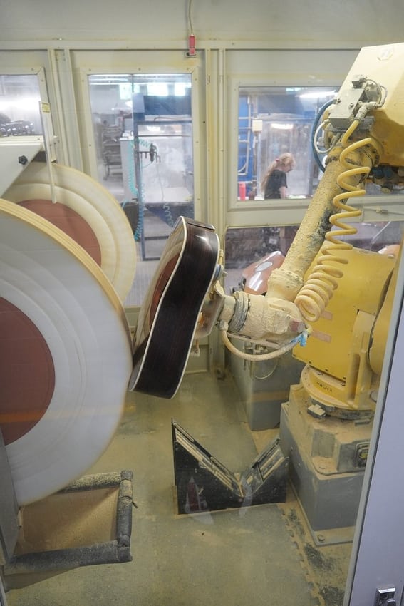A robot polishing guitars illustrates a real moving production application.