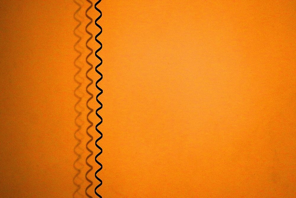 A suspended coiled cord illustrates changing reach and restoring force.