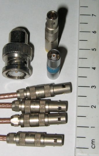 LEMO 00 coaxial connectors and adapters shown beside a scale.