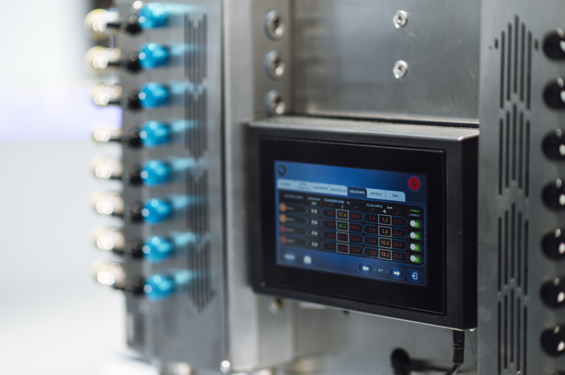 Industrial control touchscreen beside machine pipework