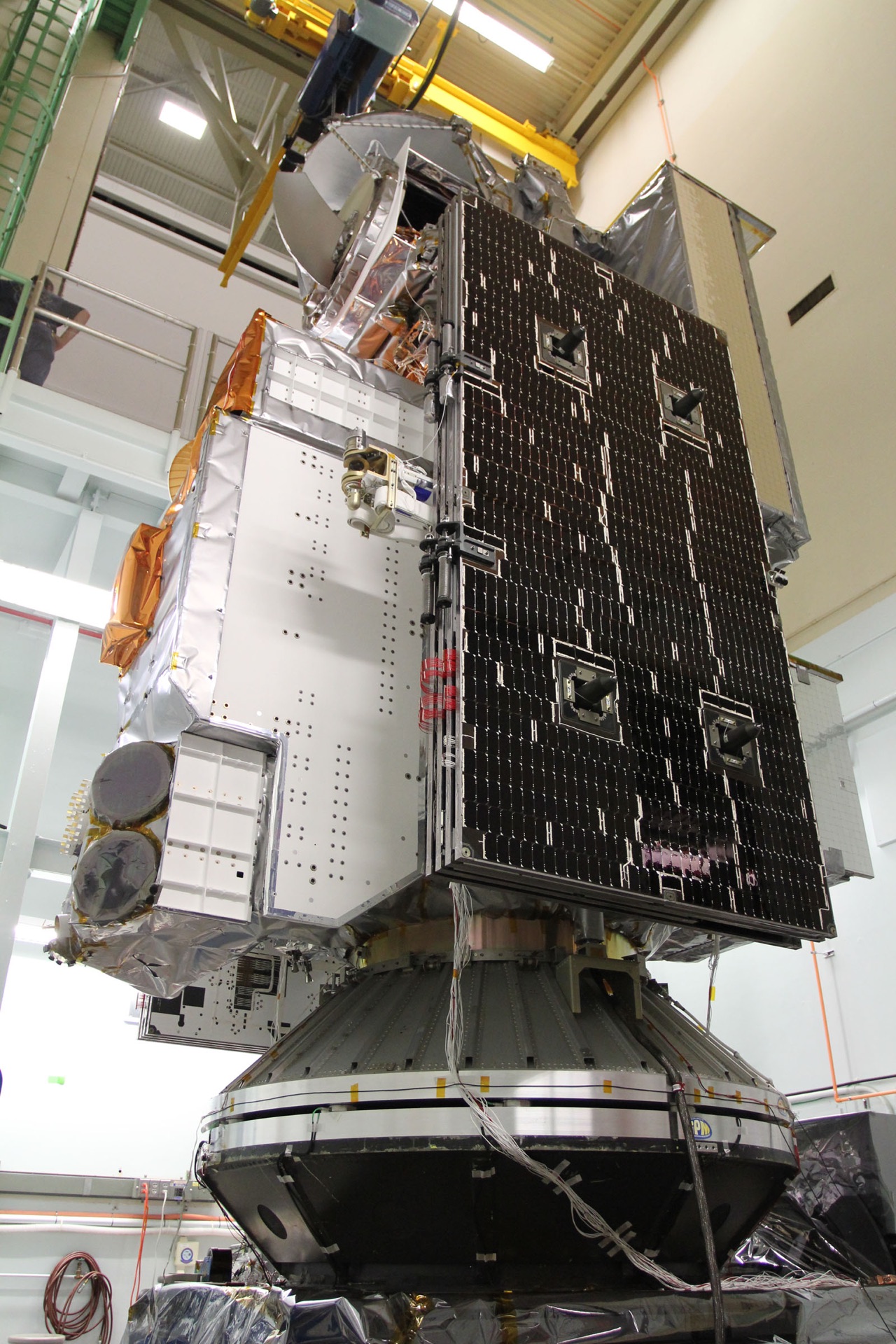 Upright satellite body and solar panel in an assembly facility