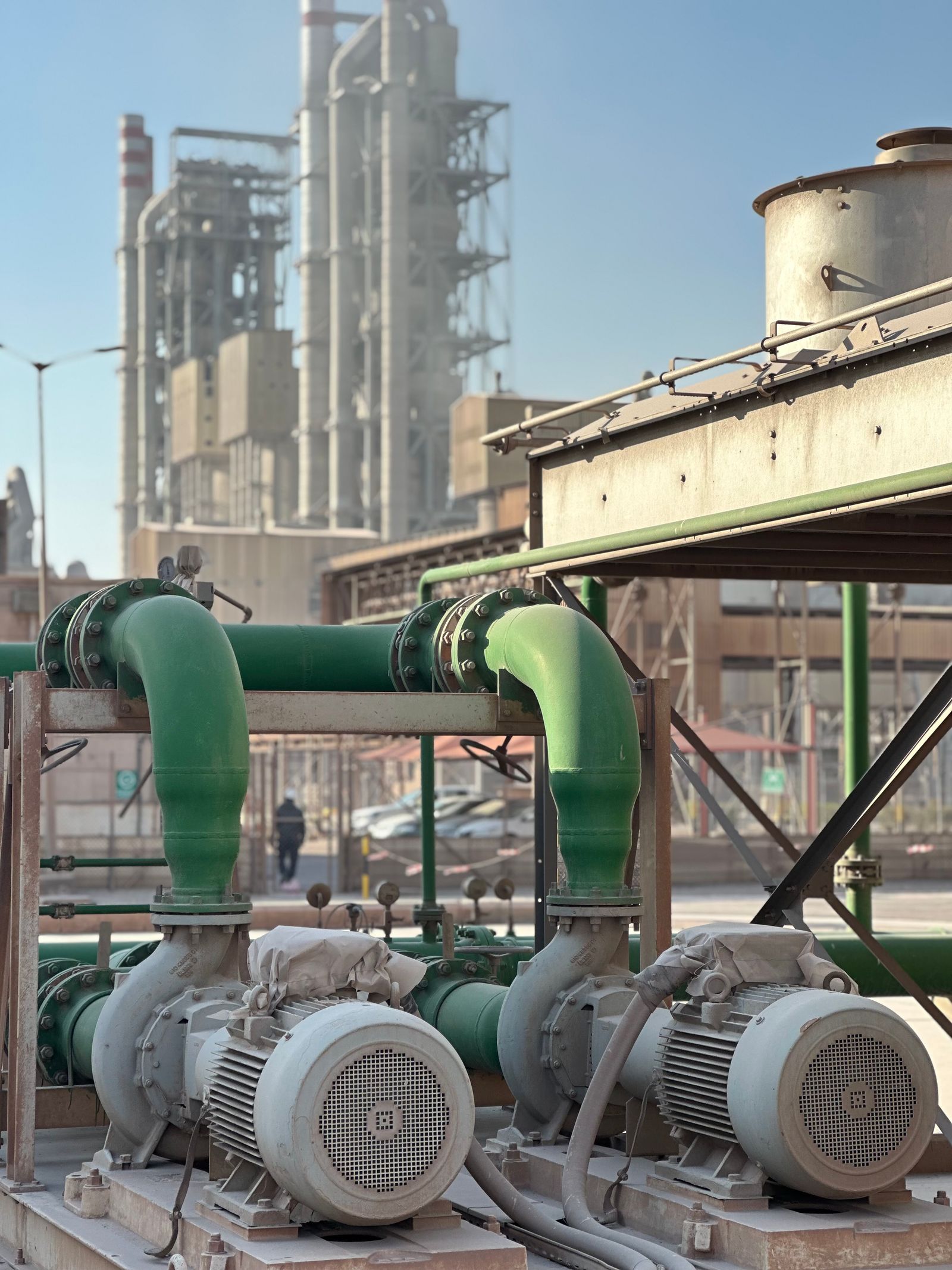 Industrial pumps and motors beside process piping