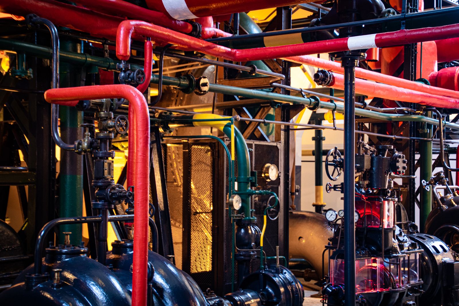 Red and gray industrial pumps and pipes at a surface facility