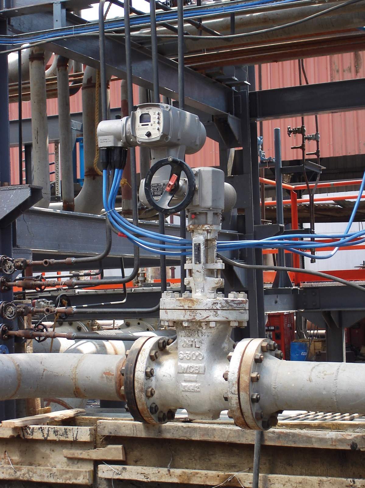 Electric valve actuator with blue cables in a refinery