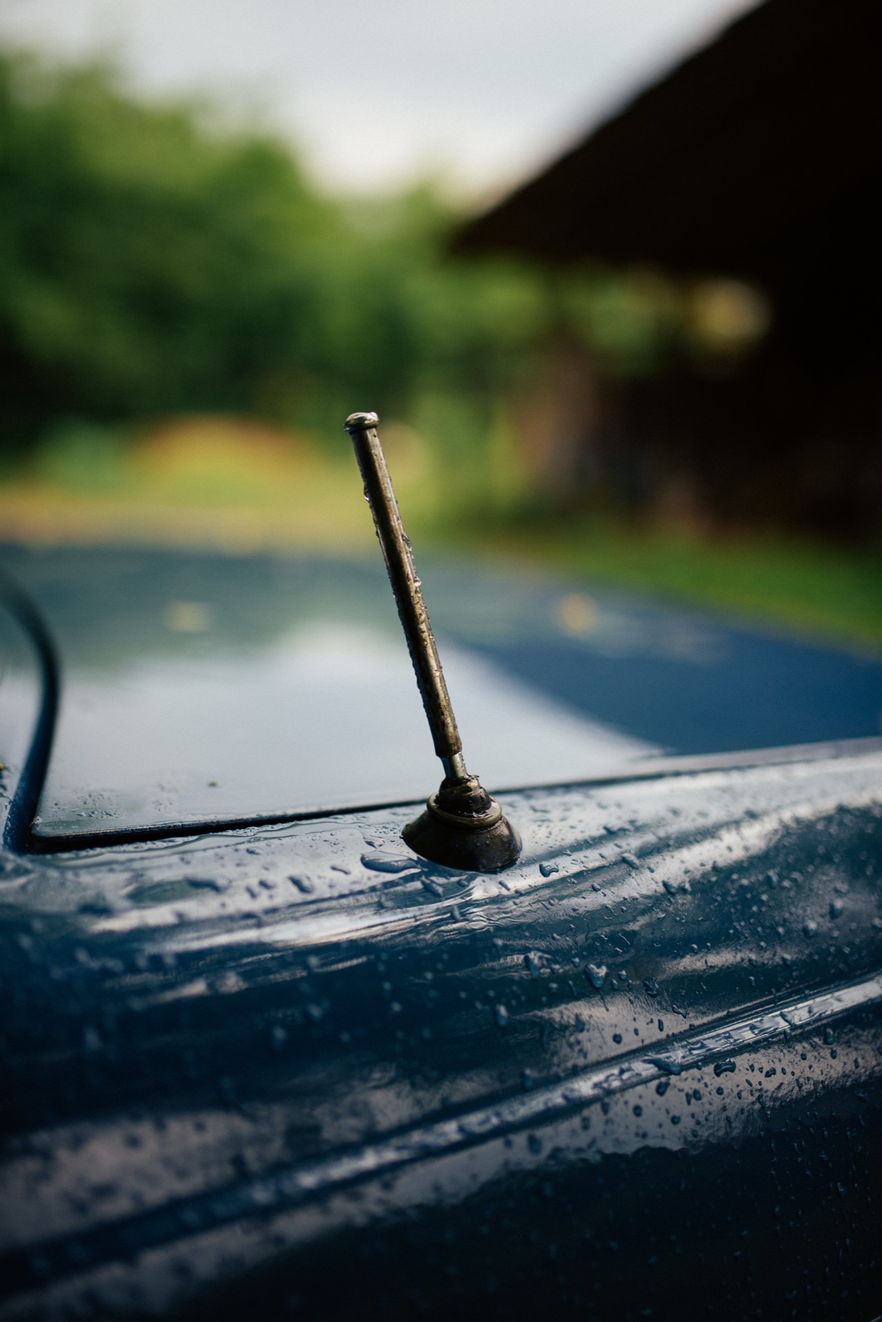 Short vehicle roof antenna covered with raindrops