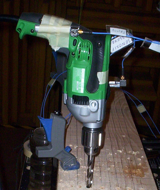 Hand drill mounted on a stand above a workbench