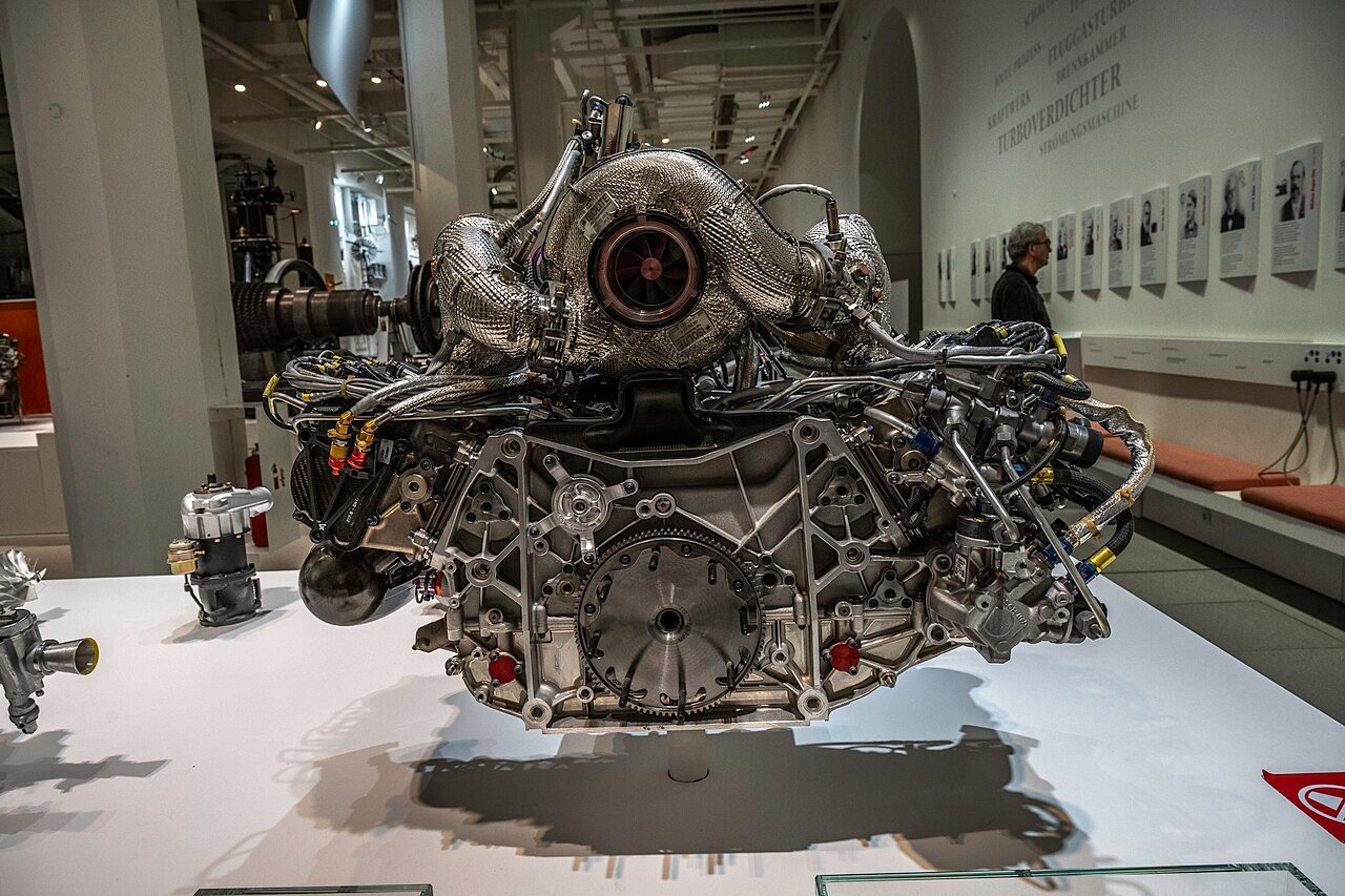 A displayed turbocharged engine illustrates the proximity of exhaust hardware and heat protection.